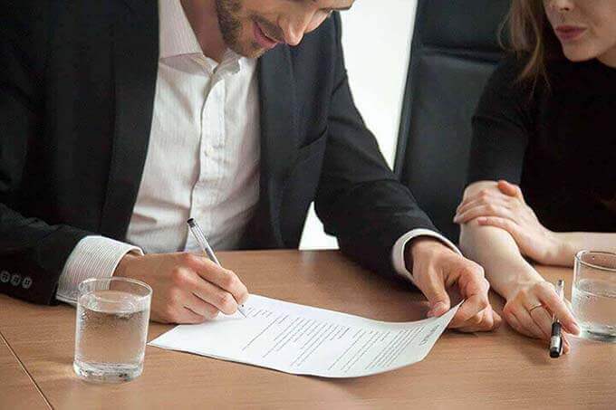 Client Signing a Legal Document with an Attorney